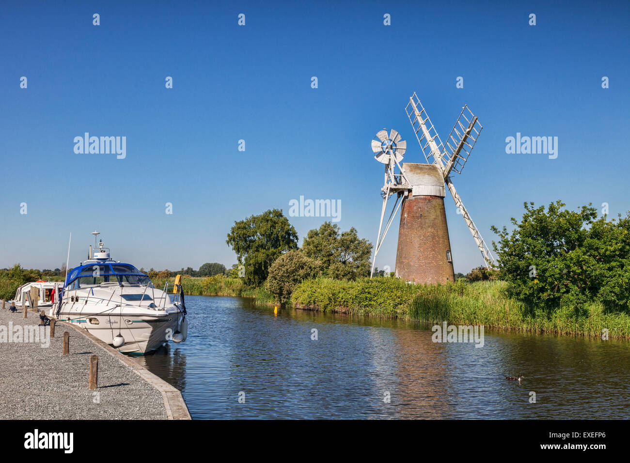 Incrociatori motore ormeggiate vicino Turf Fen Mulino a vento sulla Norfolk Broads, Norfolk, Inghilterra Foto Stock