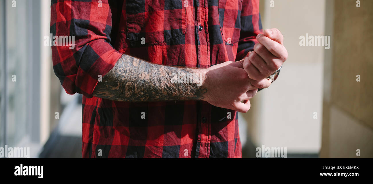 Hipster in maglietta rossa mani con tatoo Foto Stock