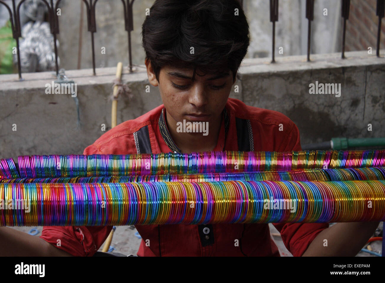 Lahore. 13 Luglio, 2015. Un lavoratore lavora in una fabbrica di bangle precedendo di Eid-al-Fitr festival in Pakistan orientale di Lahore, 13 luglio 2015. Domanda di bangle aumenta prima di Eid vacanze in Pakistan. © Jamil Ahmed/Xinhua/Alamy Live News Foto Stock