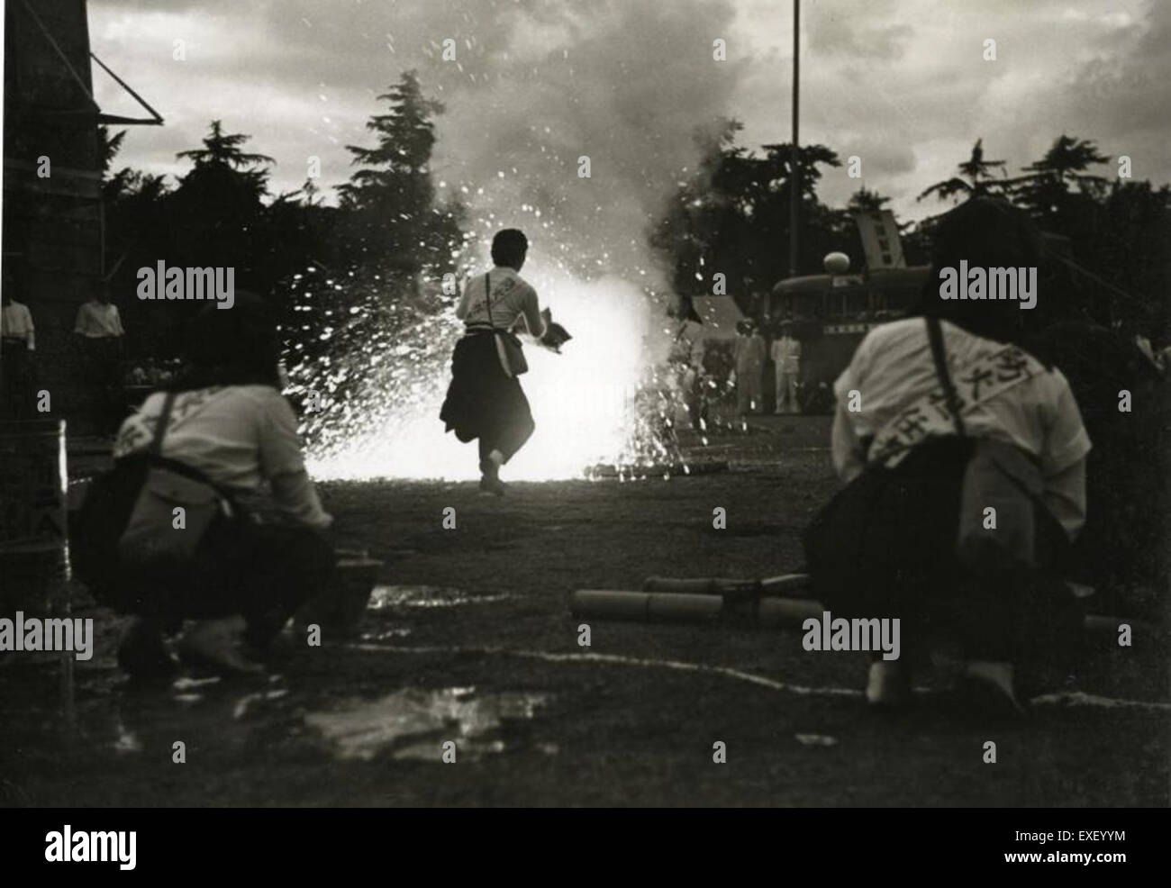 Questa immagine storica documenta un esercizio di addestramento per un attacco di gas, illustrando l'uso di bombe esplosive. Tali esercizi erano comuni durante i primi anni del XX secolo, riflettendo la preparazione alla guerra chimica durante i periodi di conflitto globale. Foto Stock