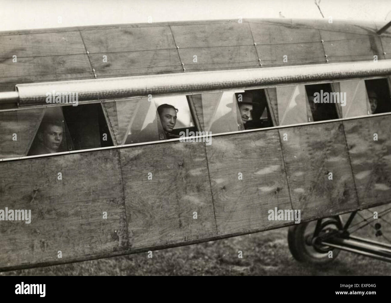 Questa fotografia mostra i passeggeri a bordo di un aereo commerciale Fokker, catturando gli interni e i passeggeri in volo. L'immagine riflette l'era dell'aviazione durante il periodo in cui l'aeromobile era in funzione. Foto Stock