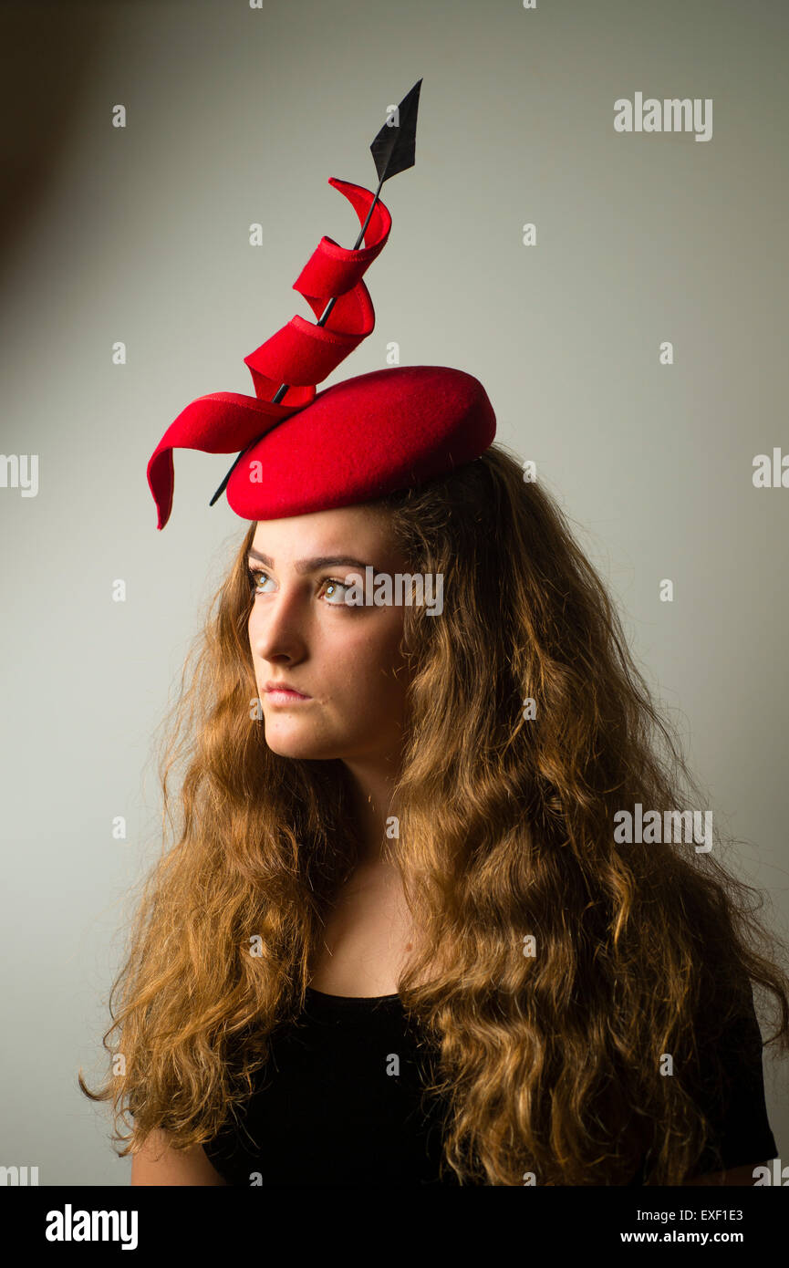 Una giovane donna di modellazione bambina indossa un cappello designer fascinator hatinator fatta di Twisted ditale millinery Foto Stock