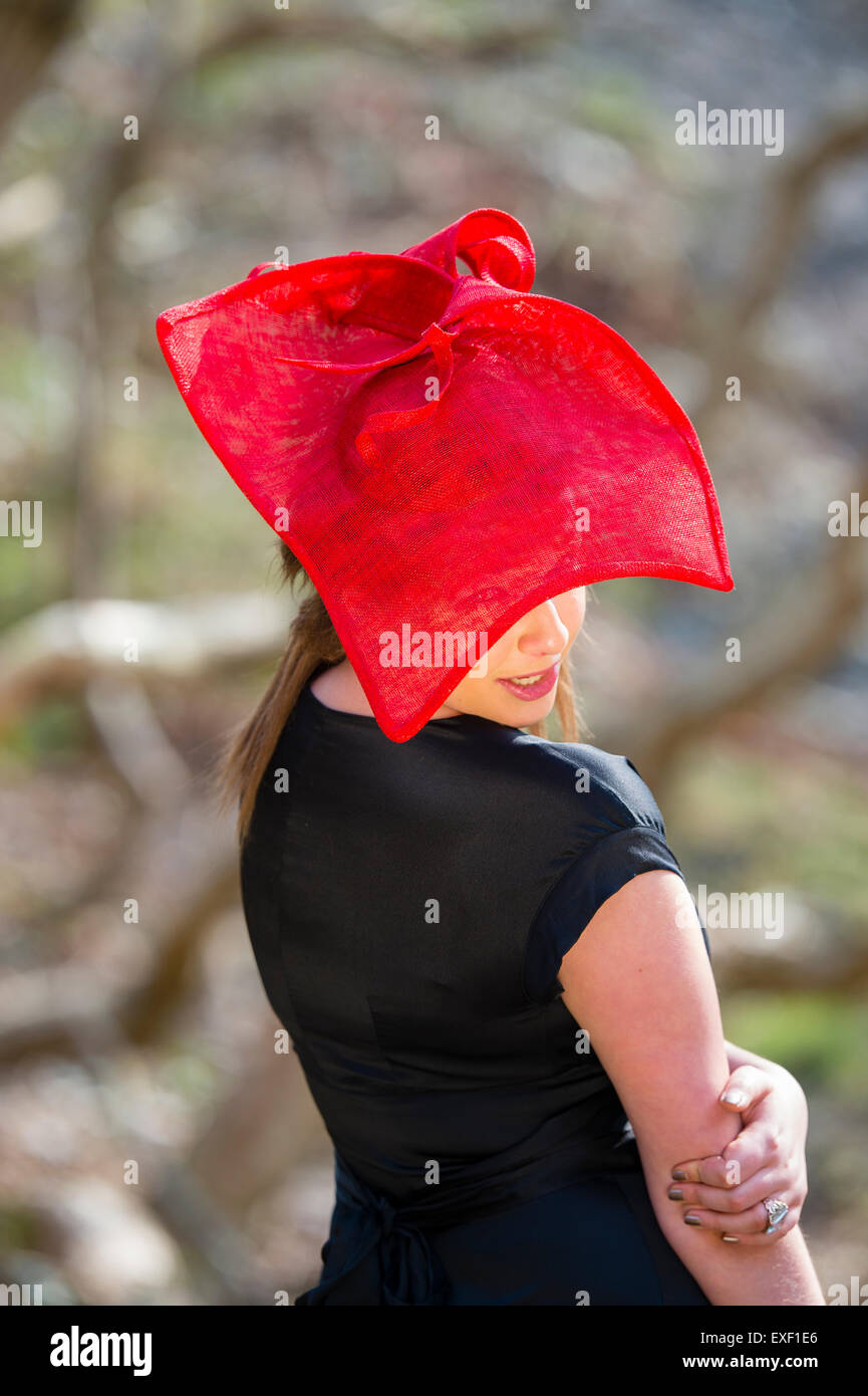 Una giovane donna di modellazione bambina indossa un cappello designer fascinator hatinator fatta di Twisted ditale millinery Foto Stock