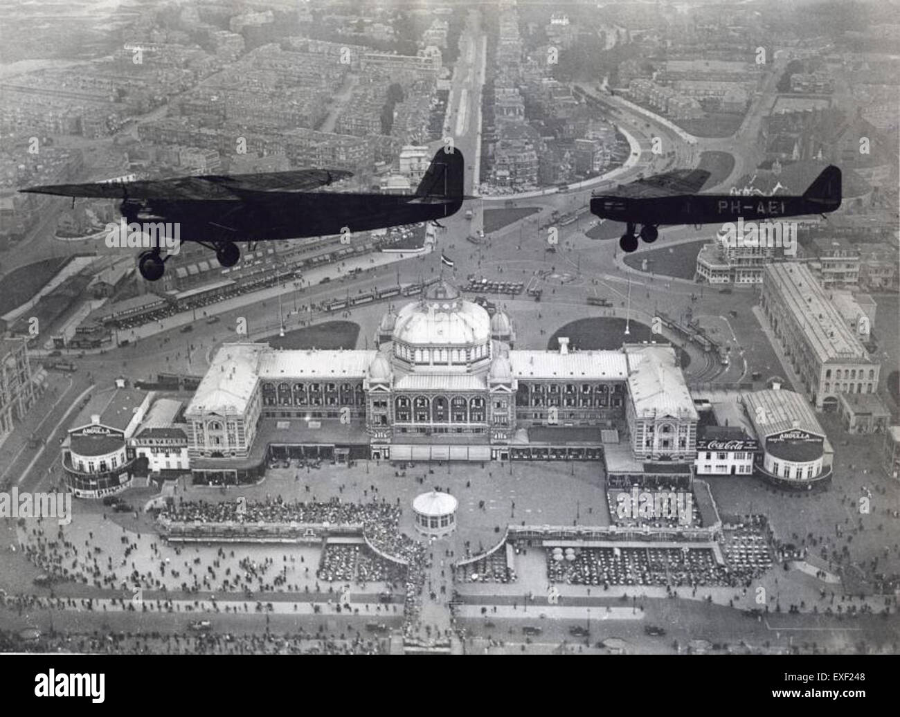 Questa fotografia cattura gli aerei Fokker che volano sopra il Kurhaus di Scheveningen, Paesi Bassi. L’immagine mette in evidenza la storia dell’aviazione dei primi anni del XX secolo e i contributi di Fokker all’aviazione. Foto Stock