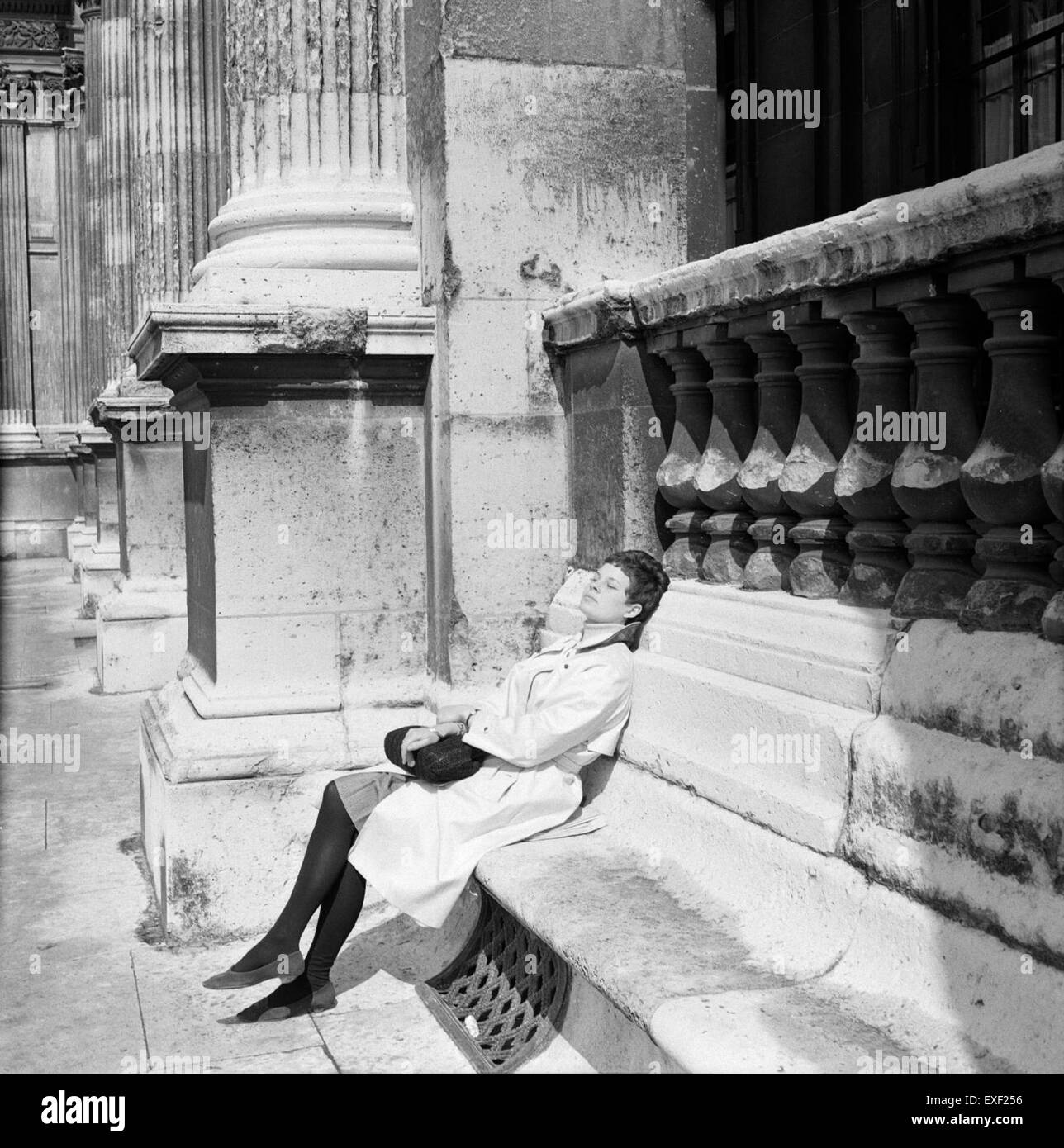 Questa immagine, intitolata *Genieten van de zon* (godersi il sole), ritrae una tranquilla scena all'aperto. Il dipinto cattura il calore e la tranquillità di una giornata di sole, evocando sensazioni di relax e soddisfazione. Foto Stock