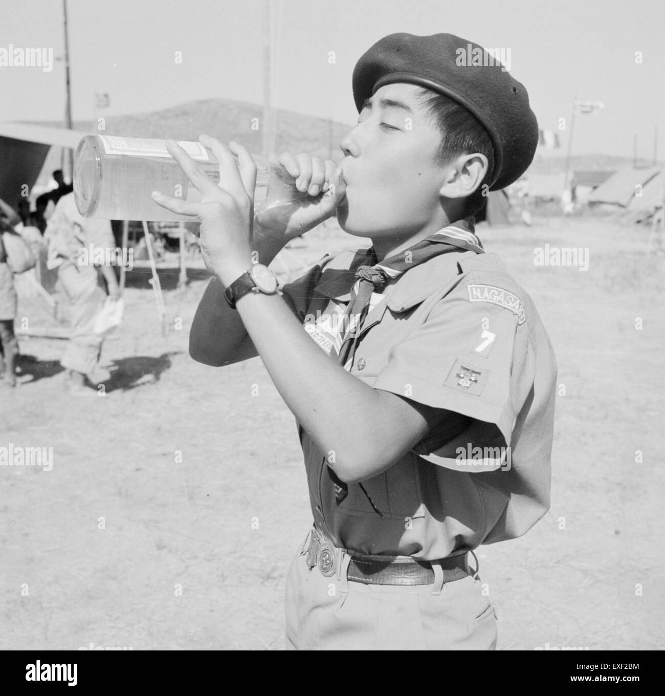 Questa fotografia mostra un esploratore giapponese che partecipa al Jamboree in Grecia, un evento scout globale. L'immagine cattura lo scout con un abbigliamento tradizionale, simboleggiando l'unità del movimento scout internazionale. Foto Stock