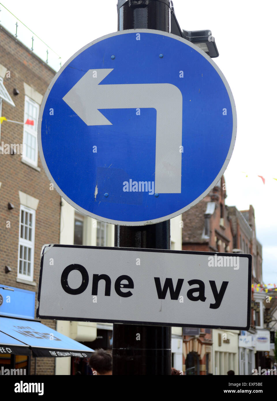 Un cartello stradale che indica una svolta a sinistra e di un sistema a senso unico. Foto Stock