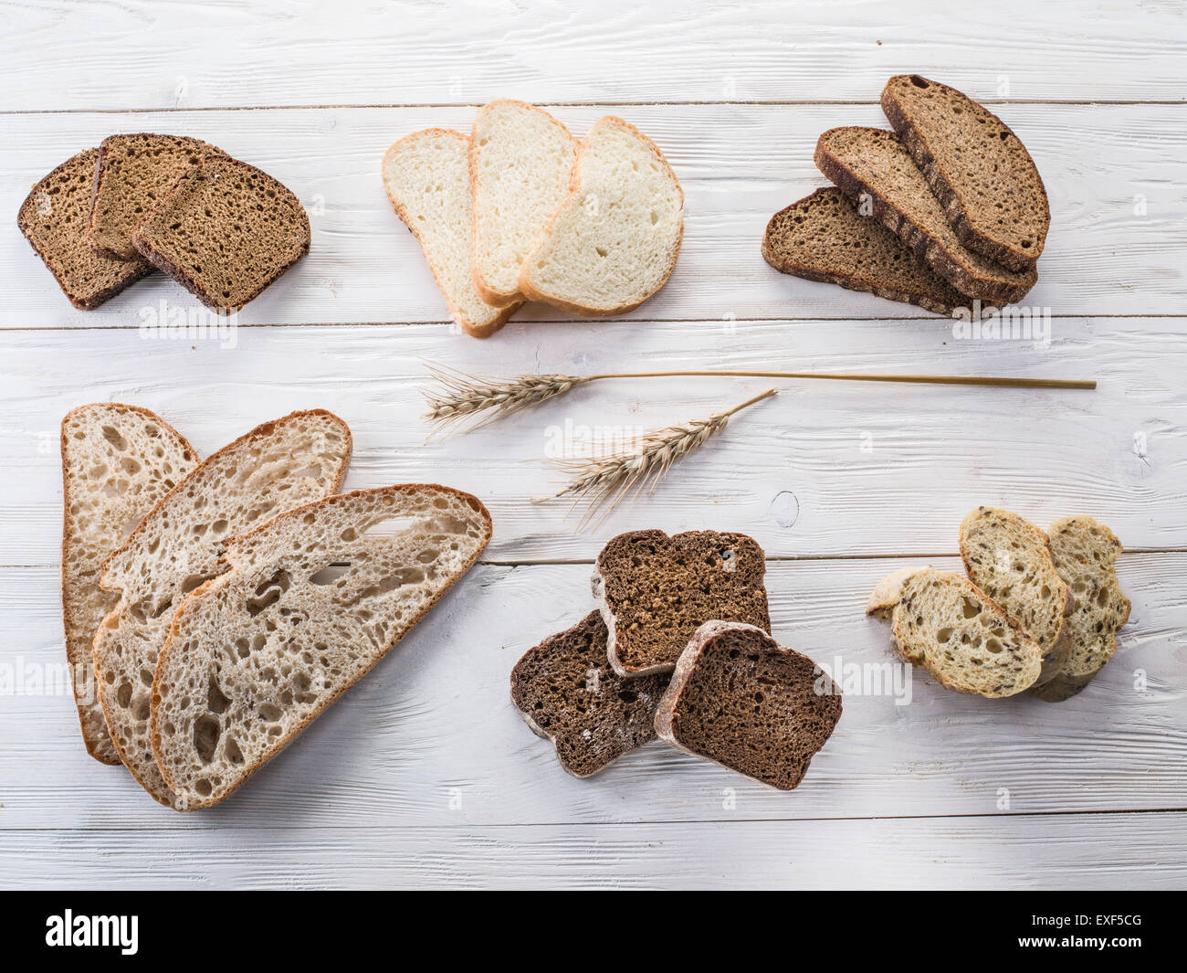 Diversi tipi di pane affettato sul vecchio tavolo in legno. Foto Stock