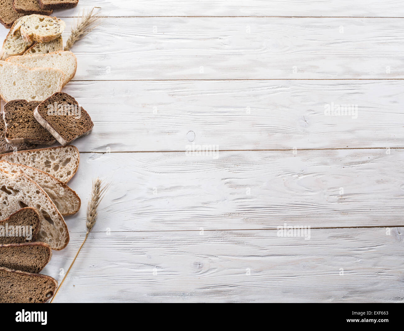 Diversi tipi di pane tagliato a fette e su sfondo di legno. Foto Stock