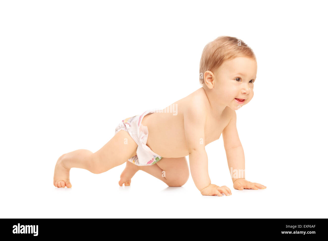 Studio shot di un adorabile piccola bambina di strisciare sul pavimento e sorridente isolati su sfondo bianco Foto Stock