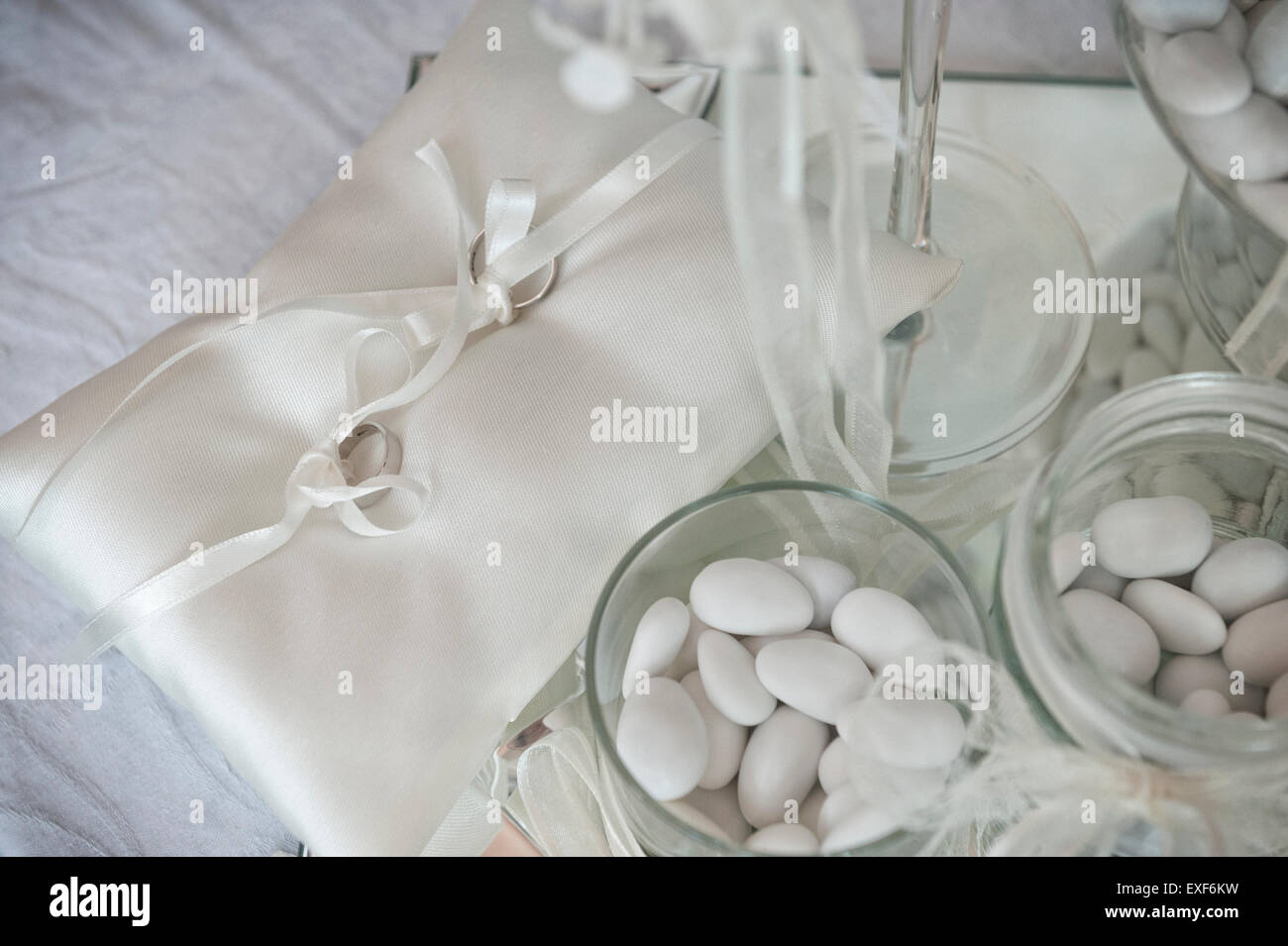 Coppia di anelli di nozze sul cuscino di piccole dimensioni e i confetti  bianchi Foto stock - Alamy