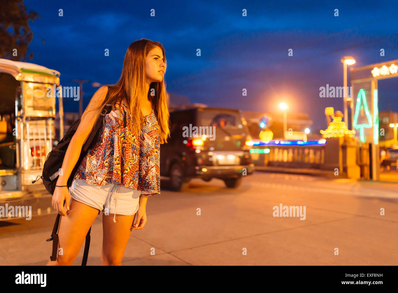 Giovane donna guardando fuori dalla strada di notte, Tagbilaran Bohol Provincia, Filippine Foto Stock