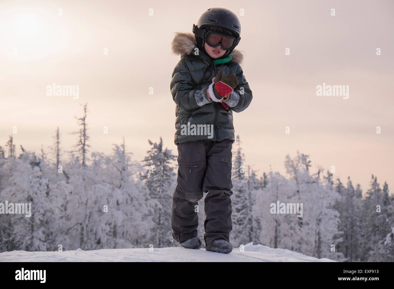 Ragazzo mettendo sul guanto nella coperta di neve la foresta, Nizhniy Tagil, nella Regione di Sverdlovsk, Russia Foto Stock