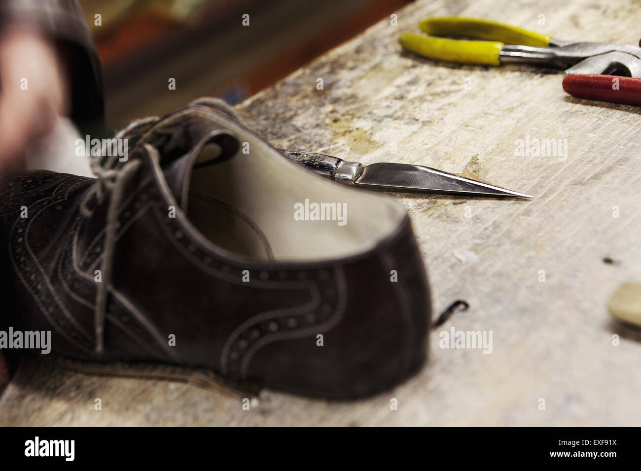 Close up brogue in pelle e utensili a mano nella calzatura maker workshop Foto Stock