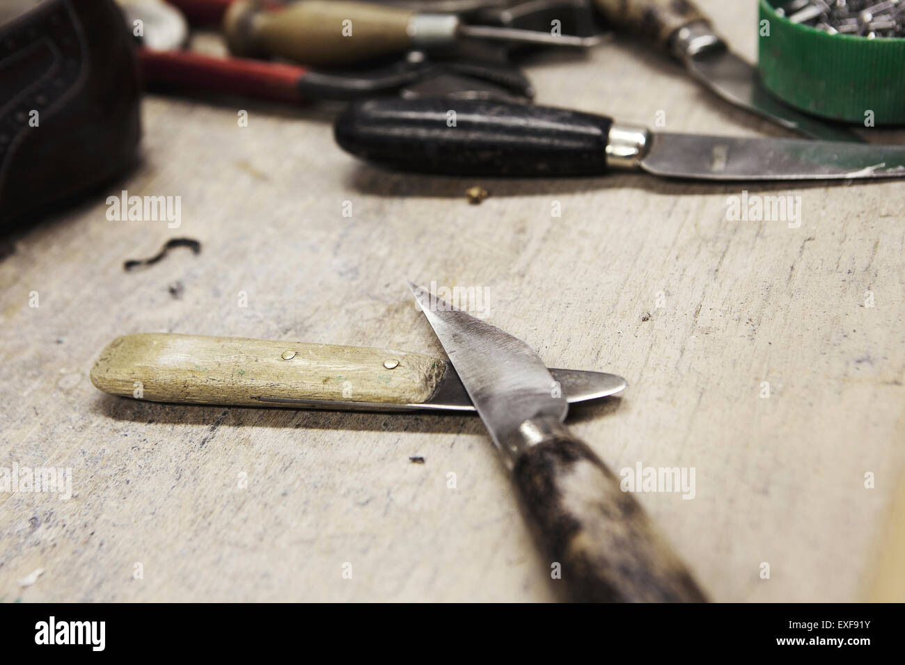 Close up dei coltelli sul banco di prova nella calzatura maker workshop Foto Stock
