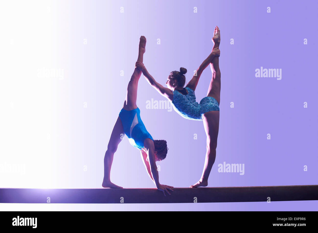 Due giovani ginnasti eseguendo sulla trave di equilibrio Foto Stock