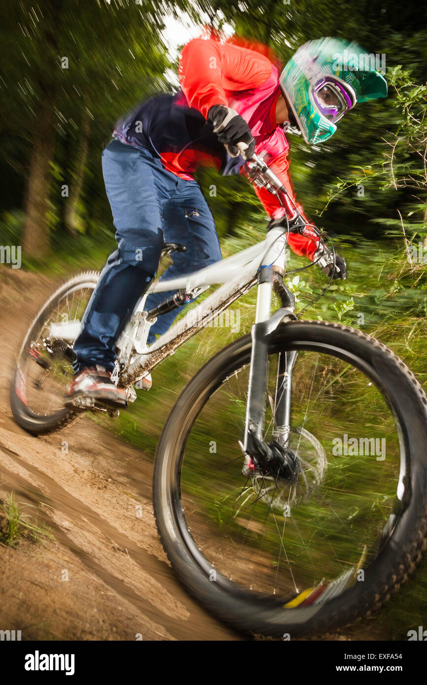Close up della giovane donna in discesa in mountain bike nella Foresta Foto Stock