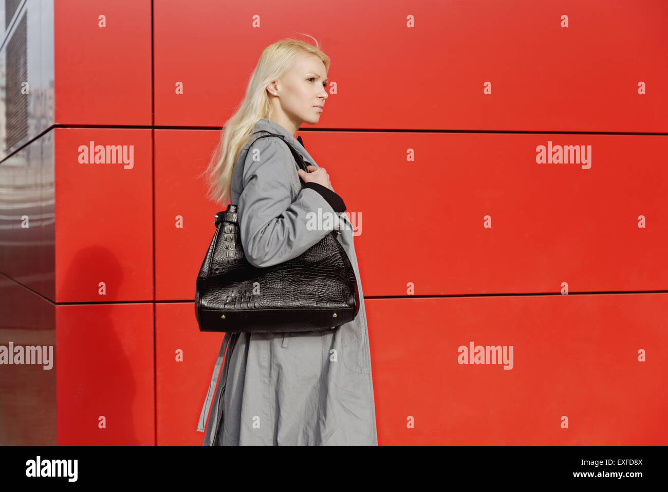 Imprenditrice, passeggiate all'aperto accanto all'edificio rosso Foto Stock