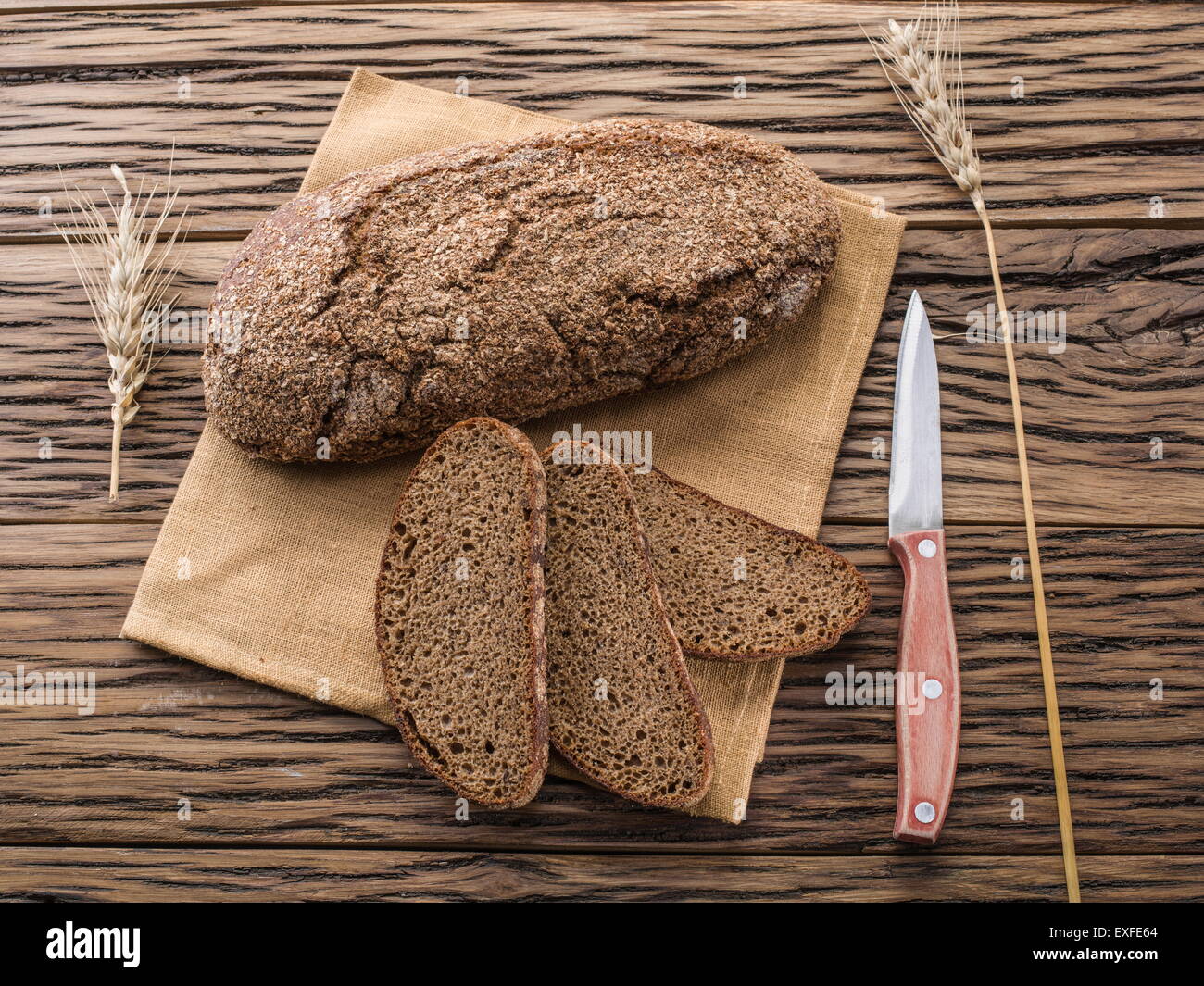 Fette di pane nero sul vecchio asse di legno. Foto Stock