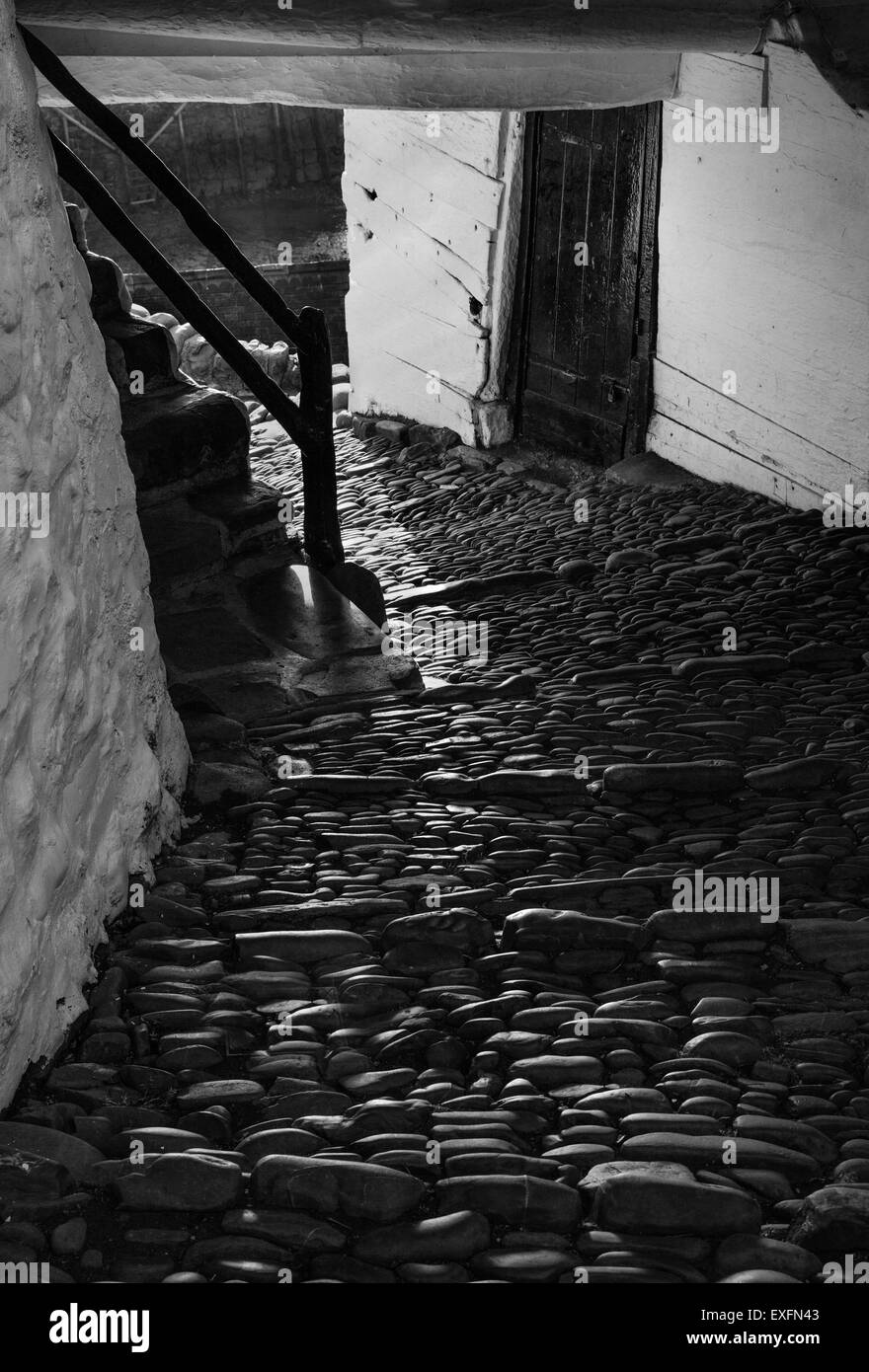 Strada basolata che passa attraverso una casa e giù al porto nel grazioso villaggio di Devon di Clovelly REGNO UNITO Foto Stock