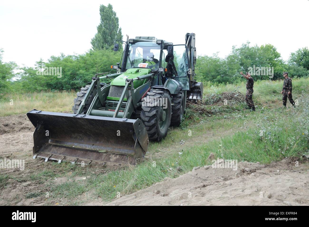 (150713) -- MORAHALOM, luglio 13, 2015 (Xinhua) -- soldati dell esercito ungherese di unità tecnica preparare i primi 175 metri di recinzione metallica al confine Hungarian-Serbian vicino villaggio Morahalom, Ungheria, il 13 luglio 2015. L'Ungheria ha annunciato lunedì che aveva iniziato a costruire un recinto su un tratto della sua frontiera con la Serbia appena a sud della città di Morahalom. Ungheria inizialmente ha annunciato la sua intenzione di costruire un 175 km di lunghezza, quattro-metro-alto recinto lungo tutta la sua frontiera con la Serbia il 17 giugno, citando un enorme e crescente onda illegali di valichi di frontiera. (Xinhua/Stampa Ungherese agenzia/Gergely Z Foto Stock