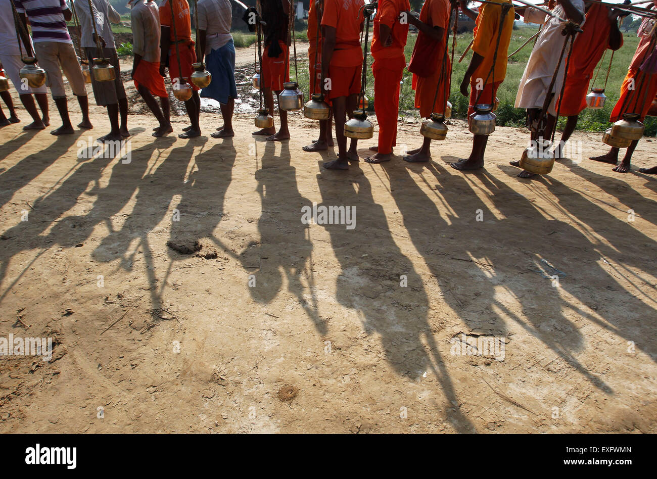 Di Allahabad, India. 13 Luglio, 2015. Kanwarias indù, adoratori di Dio indù Shiva, trasportare contenitori metallici riempiti con acqua santa di Gange fiume come si cammina verso Padilla Mahadev tempio sulla periferia di Allahabad. © Ravi Prakash/Pacific Press/Alamy Live News Foto Stock