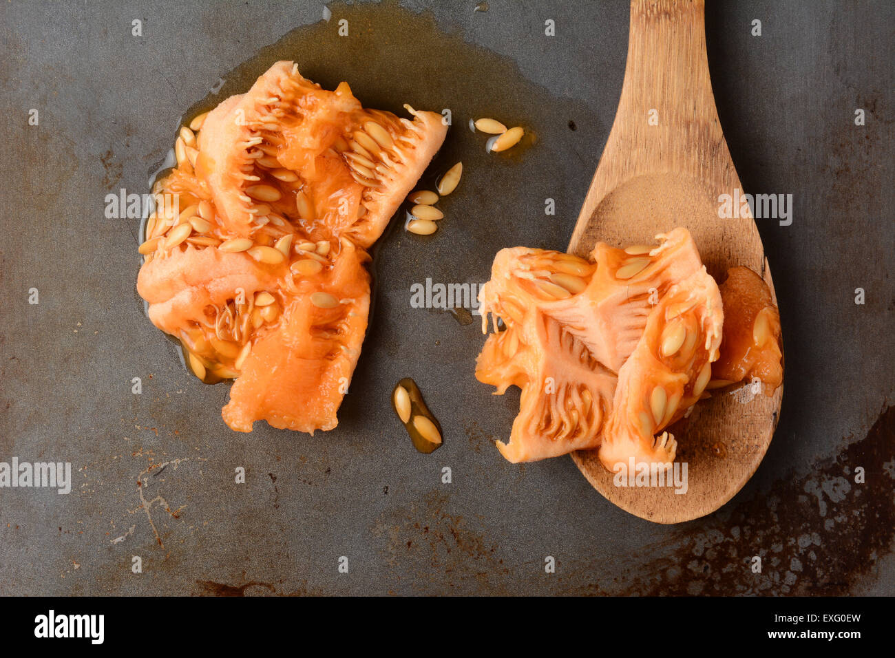 Alta angolazione del raccolto fuori di sementi e di carne di un melone con un cucchiaio di legno e la semina polpa. Vista aerea in oriz Foto Stock