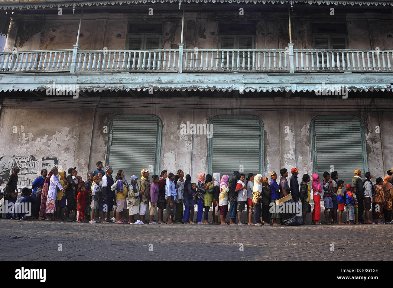 Di Semarang, Giava centrale, Indonesia. 11 Luglio, 2015. Di SEMARANG, Indonesia - 11 luglio: migliaia di persone in fila per ricevere elemosina davanti al Haji Layung casa di città vecchia sulla luglio 11, 2015 a Semarang, Java centrale provincia, Indonesia. I musulmani per la fine del Ramadan effettuerà il pagamento della zakat ai poveri. © Sijori Immagini/ZUMA filo/Alamy Live News Foto Stock