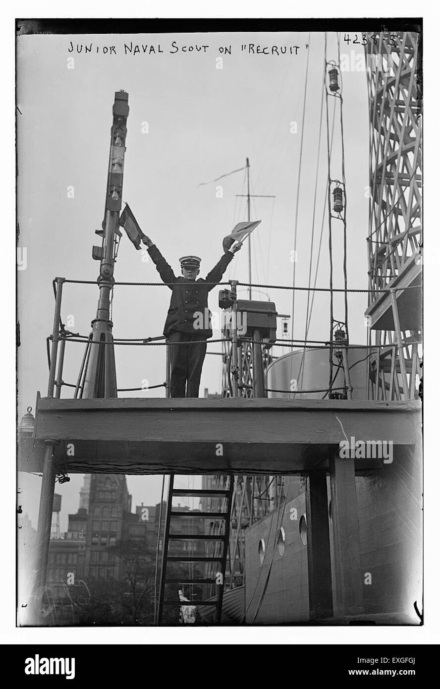 Questa fotografia mostra un Junior Naval Scout a bordo della nave da addestramento RECLUTE. Lo scout è impegnato in attività di addestramento di base, evidenziando il processo di reclutamento navale e le prime fasi del servizio navale. Foto Stock