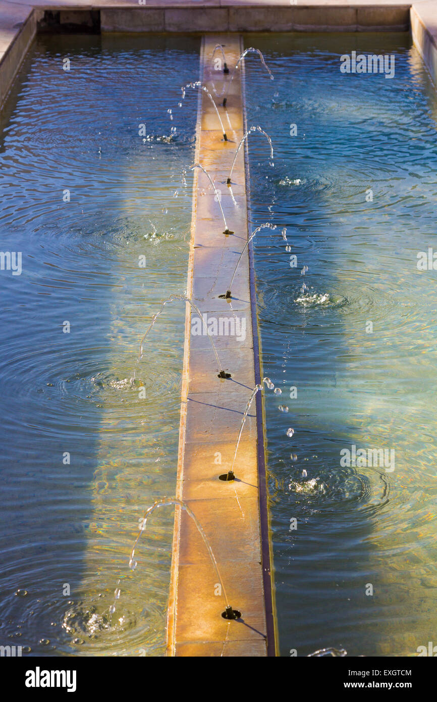 Piccolo laghetto con diversi getti d'acqua online Foto Stock