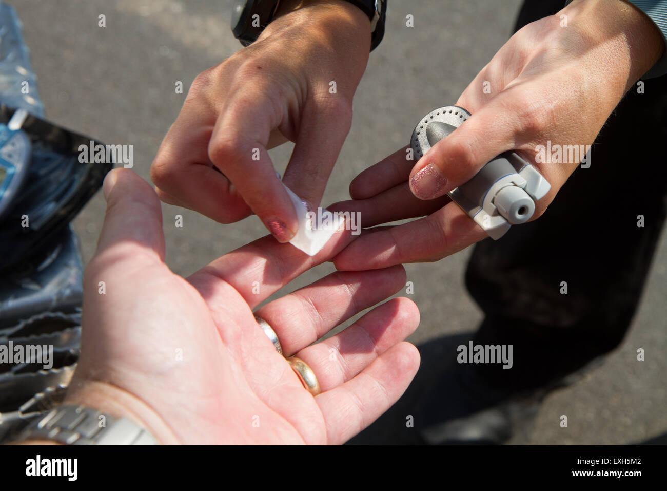 EMT / Paramedic amministra i livelli di zucchero nel sangue test in ambulanza. Foto Stock