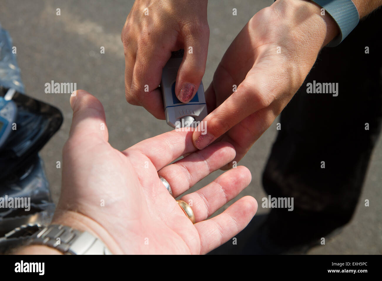 EMT / Paramedic amministra i livelli di zucchero nel sangue test in ambulanza. Foto Stock