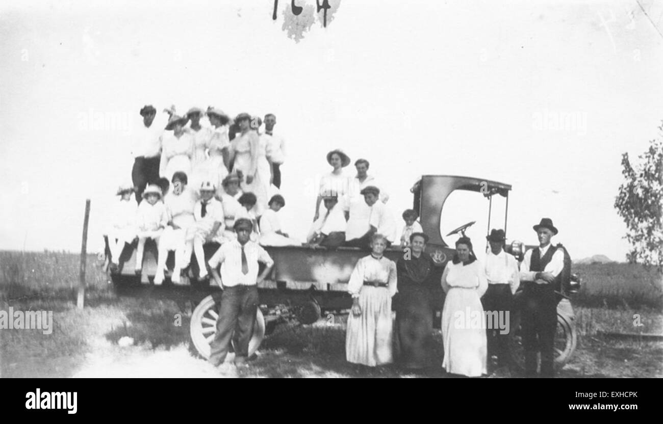 Un gruppo di persone viene radunato intorno o su un camion, probabilmente durante un'attività di trasporto o di sensibilizzazione, catturato in un momento schietto. Il contesto o lo scopo non sono specificati. Foto Stock