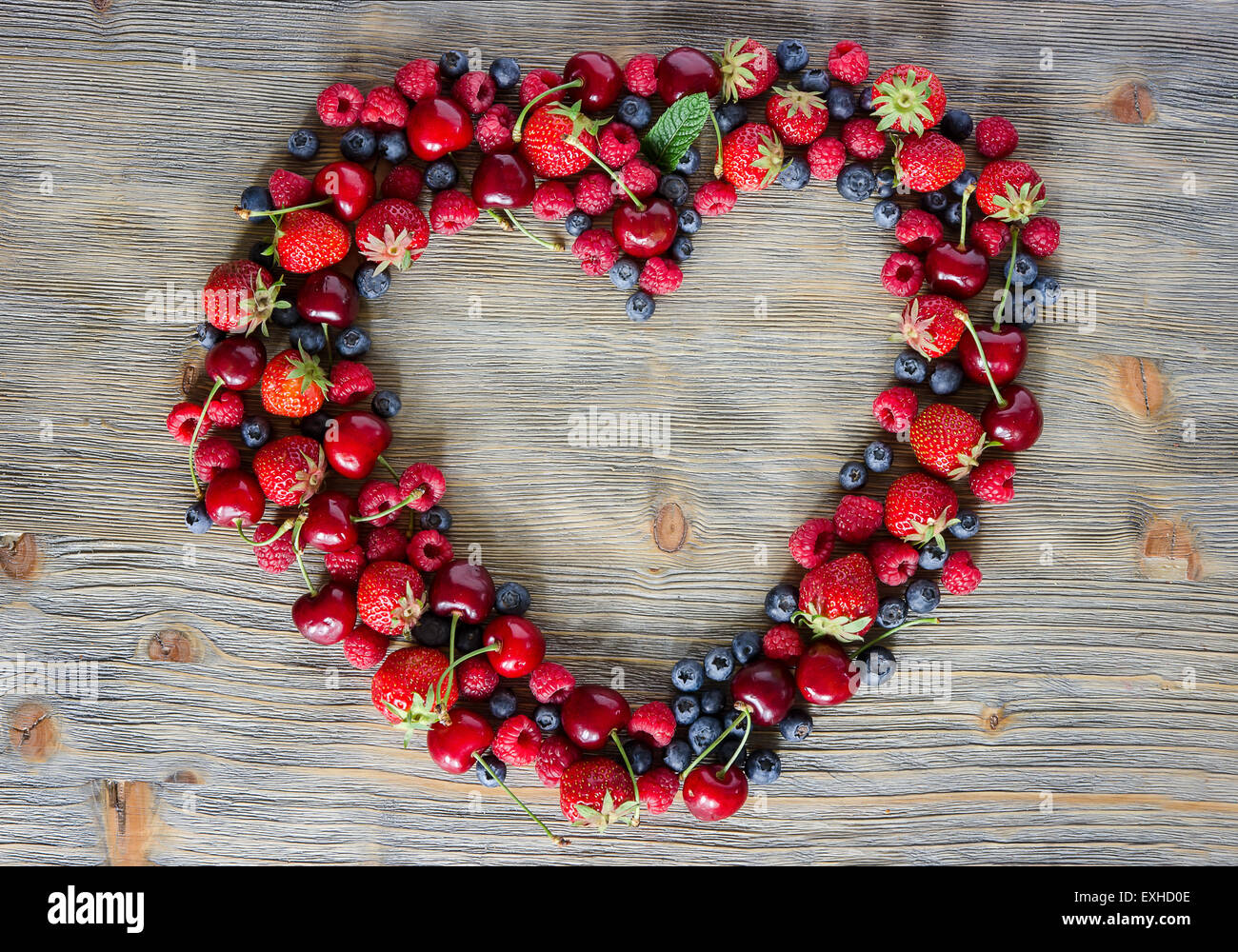 Fresco di frutti di bosco maturi, ciliegie, lamponi mirtilli un sacco di spazio copia, sullo sfondo di legno, frutta estiva, harvest concetto, vi Foto Stock