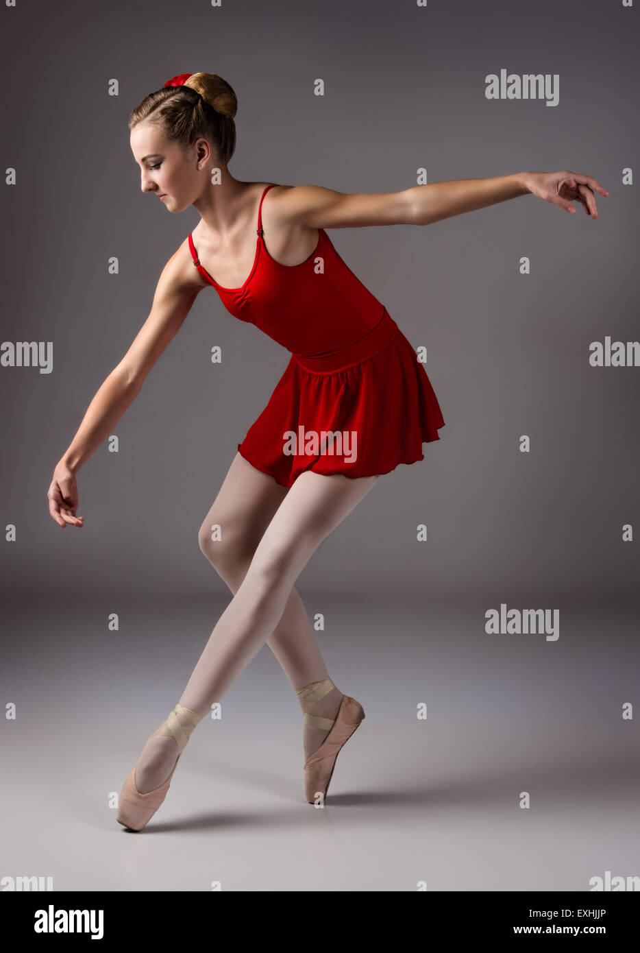 Bellissima femmina ballerina su sfondo grigio. Ballerina indossa un body  rosso, rosa calze, pointe scarpe e un rosso Foto stock - Alamy