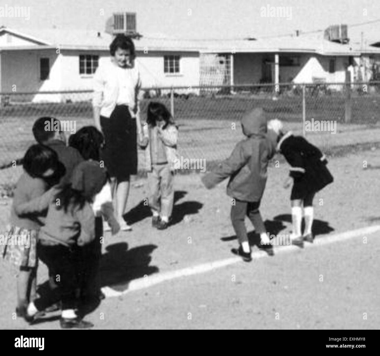 "Playtime Surprise" di Leanne Yoder cattura un momento di gioia con i bambini impegnati in attività ludiche a Surprise, Arizona. Il dipinto mostra la semplicità e la gioia dell'infanzia, mettendo in risalto la vivace comunità e l'atmosfera vivace. Foto Stock