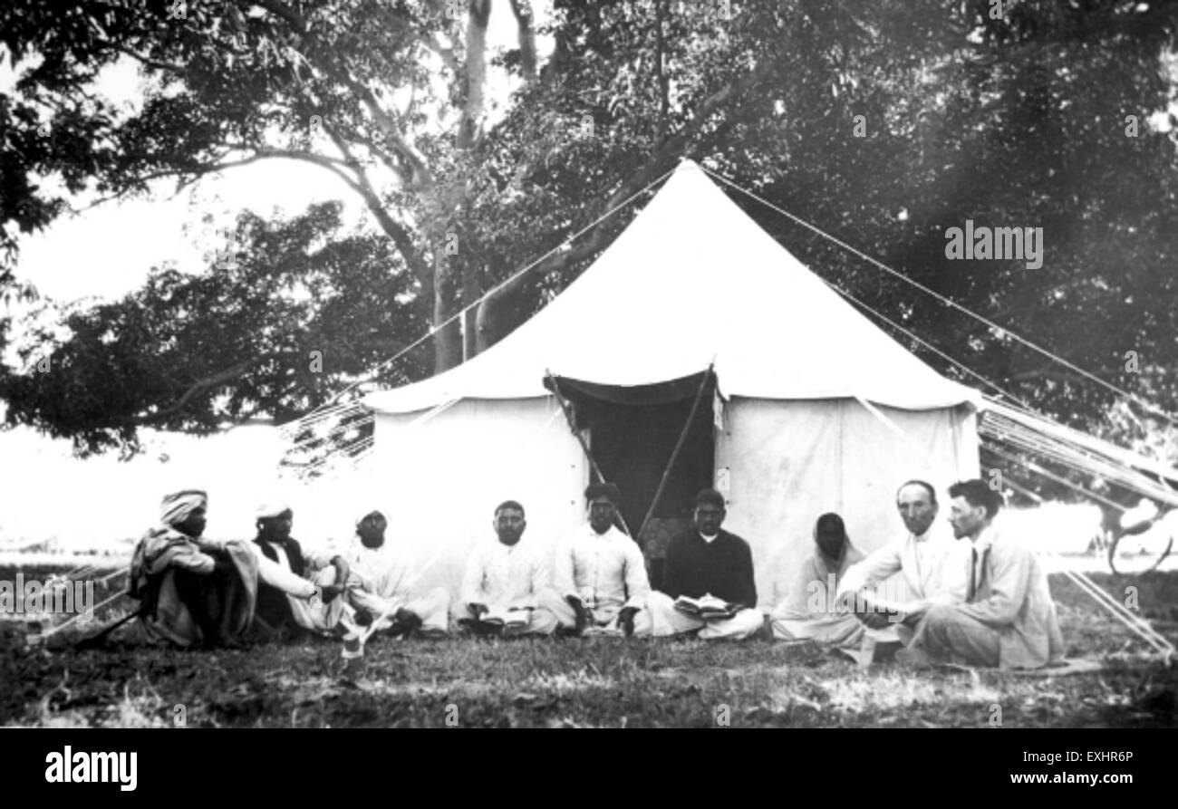 Questa fotografia cattura un gruppo di uomini e una tenda in India, evidenziando un momento storico della vita rurale. L'immagine ondulata riflette lo stile di vita e l'abbigliamento della regione, offrendo uno sguardo sulla vita quotidiana in India. Foto Stock