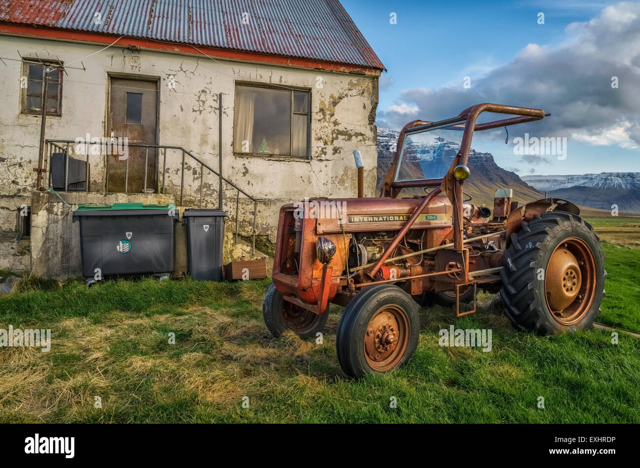 Vecchio trattore di fronte decadendo agriturismo, western Islanda Foto Stock