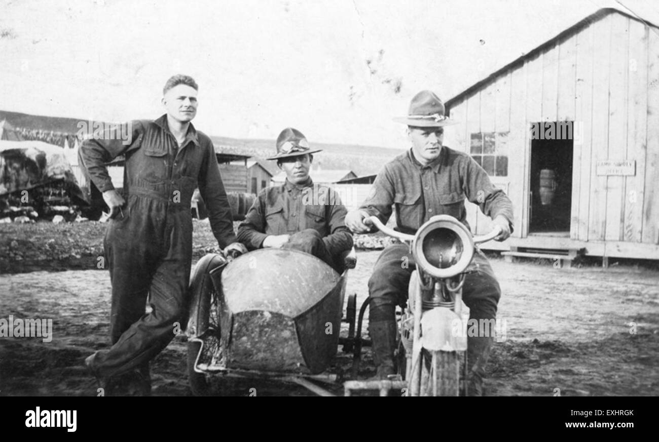 Una fotografia storica che mostra tre uomini in piedi accanto a una moto con sidecar, rappresentando l'uso delle moto nel trasporto e nel tempo libero all'inizio del XX secolo. Foto Stock