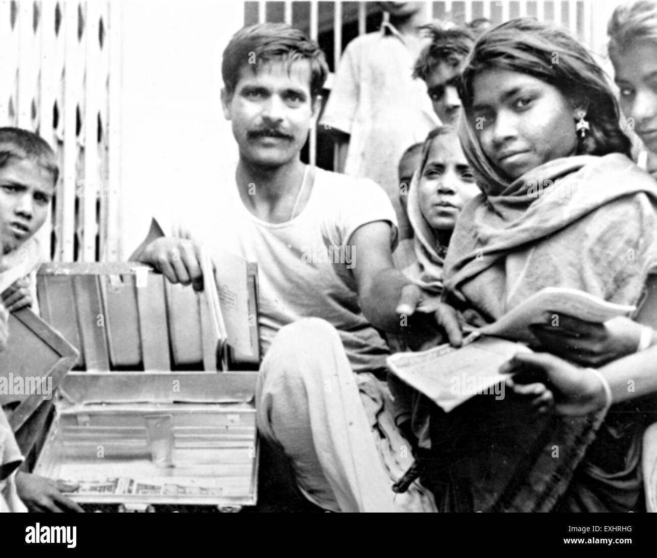 Questa fotografia del 1963 mostra una biblioteca di latta in India, che offre uno sguardo sul modo intraprendente dell'epoca di conservare la letteratura in contenitori portatili e compatti. L'immagine mostra l'uso pratico dei tronchi di latta come librerie mobili. Foto Stock