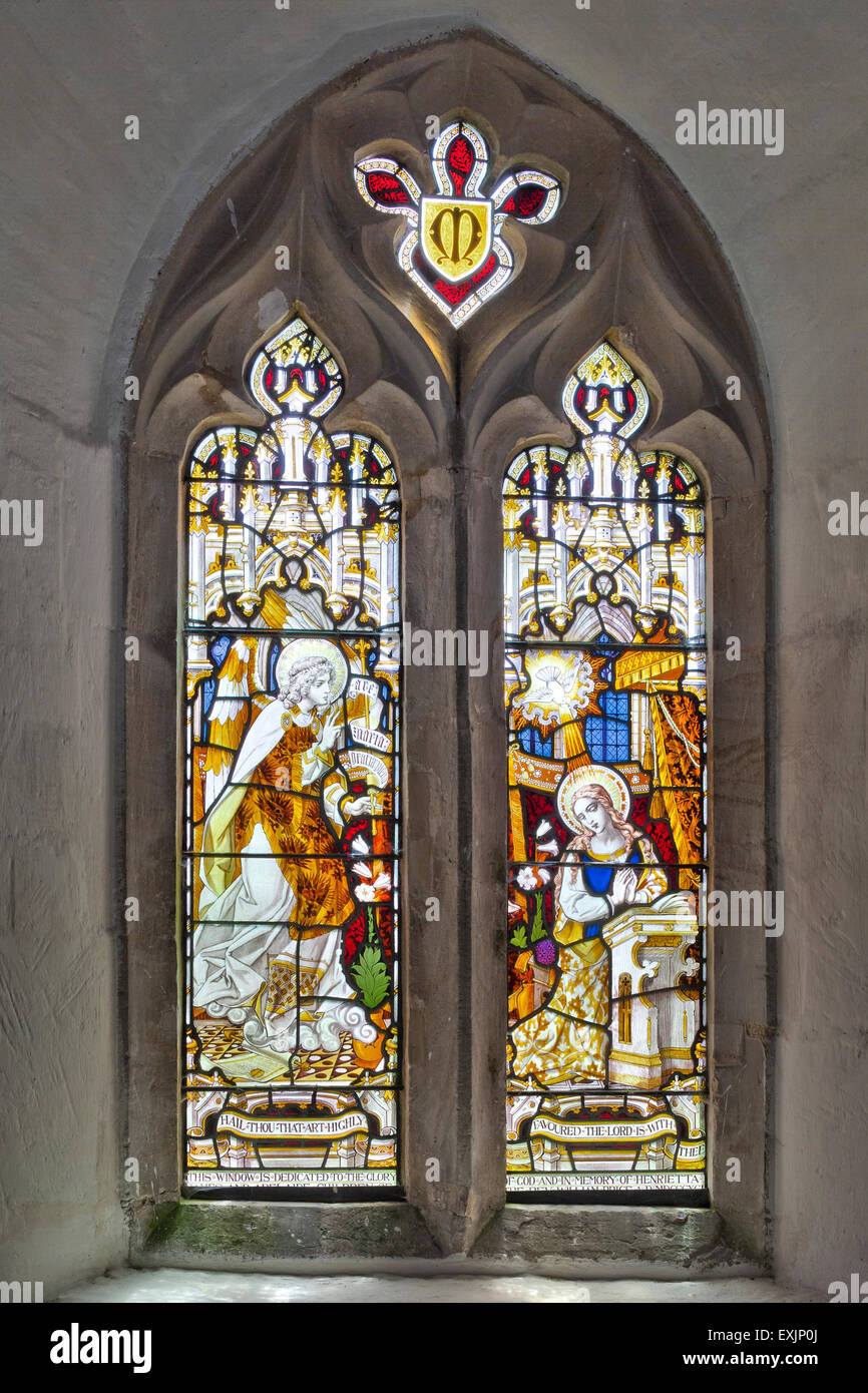 La chiesa normanna a Coln St Dennis, Gloucestershire, Regno Unito - Victorian vetrata raffigurante l'Annunciazione di Maria Vergine Foto Stock