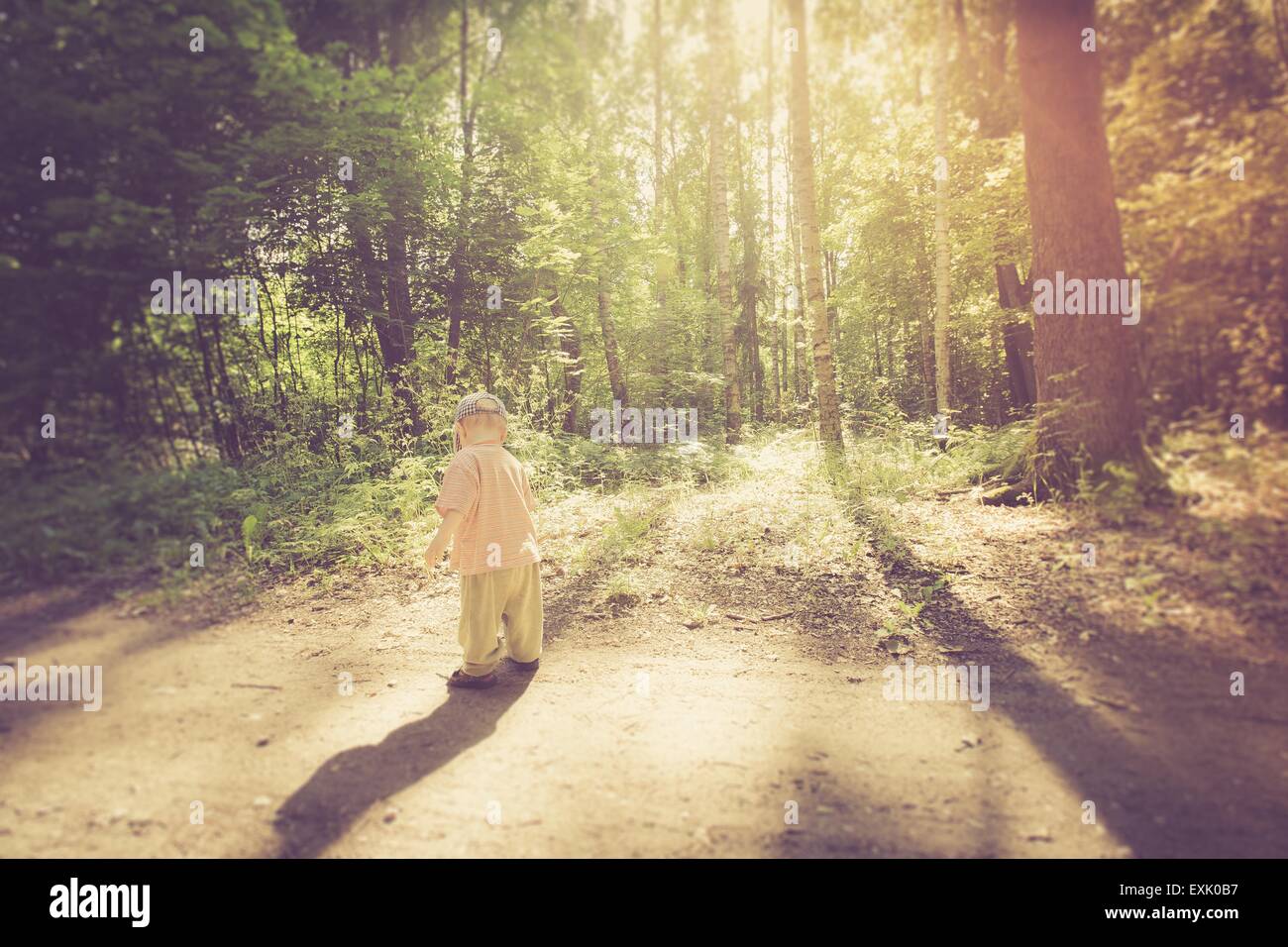 Foto d'epoca del ragazzo giocando nella foresta. Infanzia bello trascorrere con la natura. Foto Stock