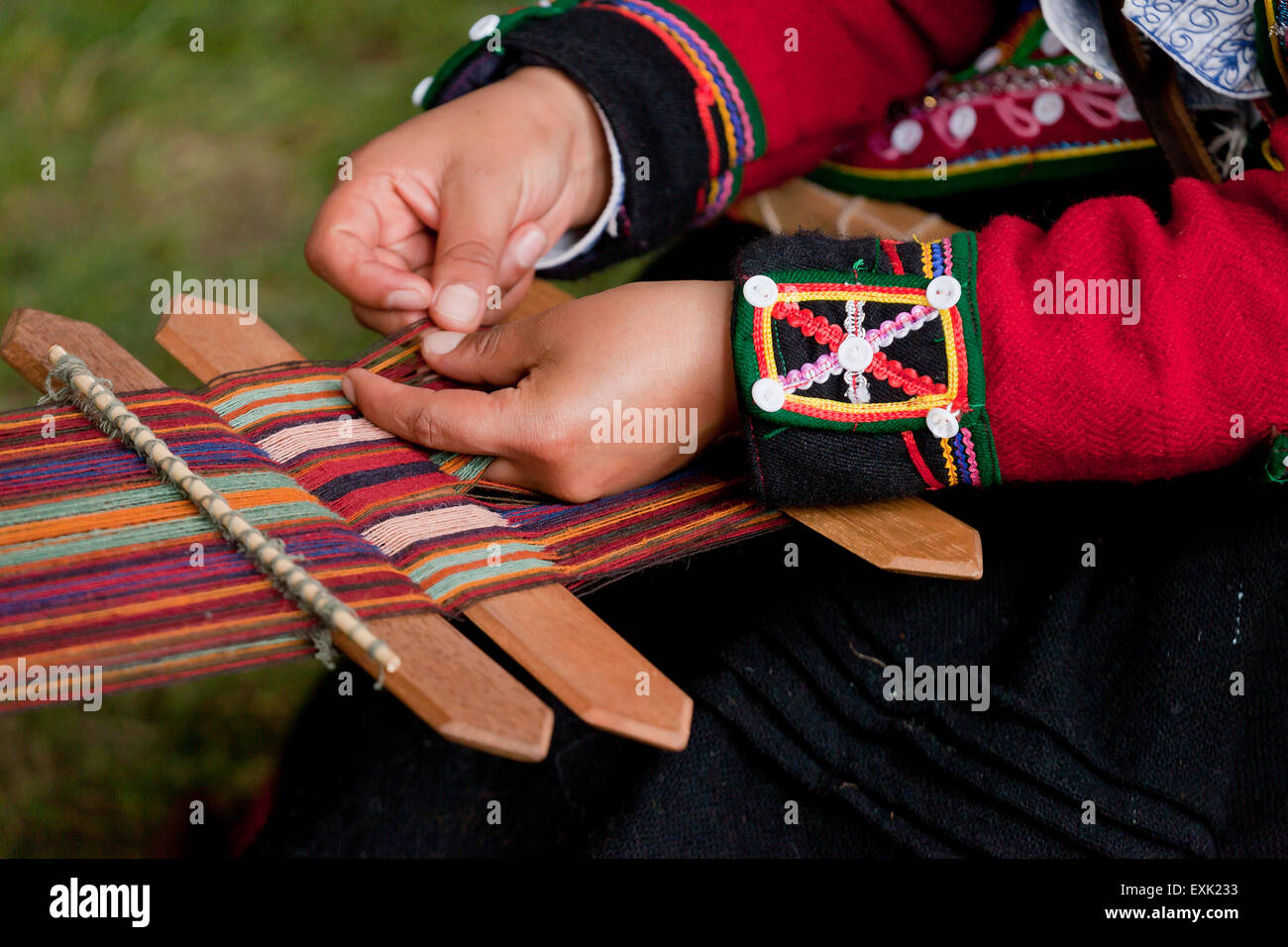 Donna Peruviana da Chinchero tessitura tessuto tradizionale mediante fascetta posteriore telaio Foto Stock
