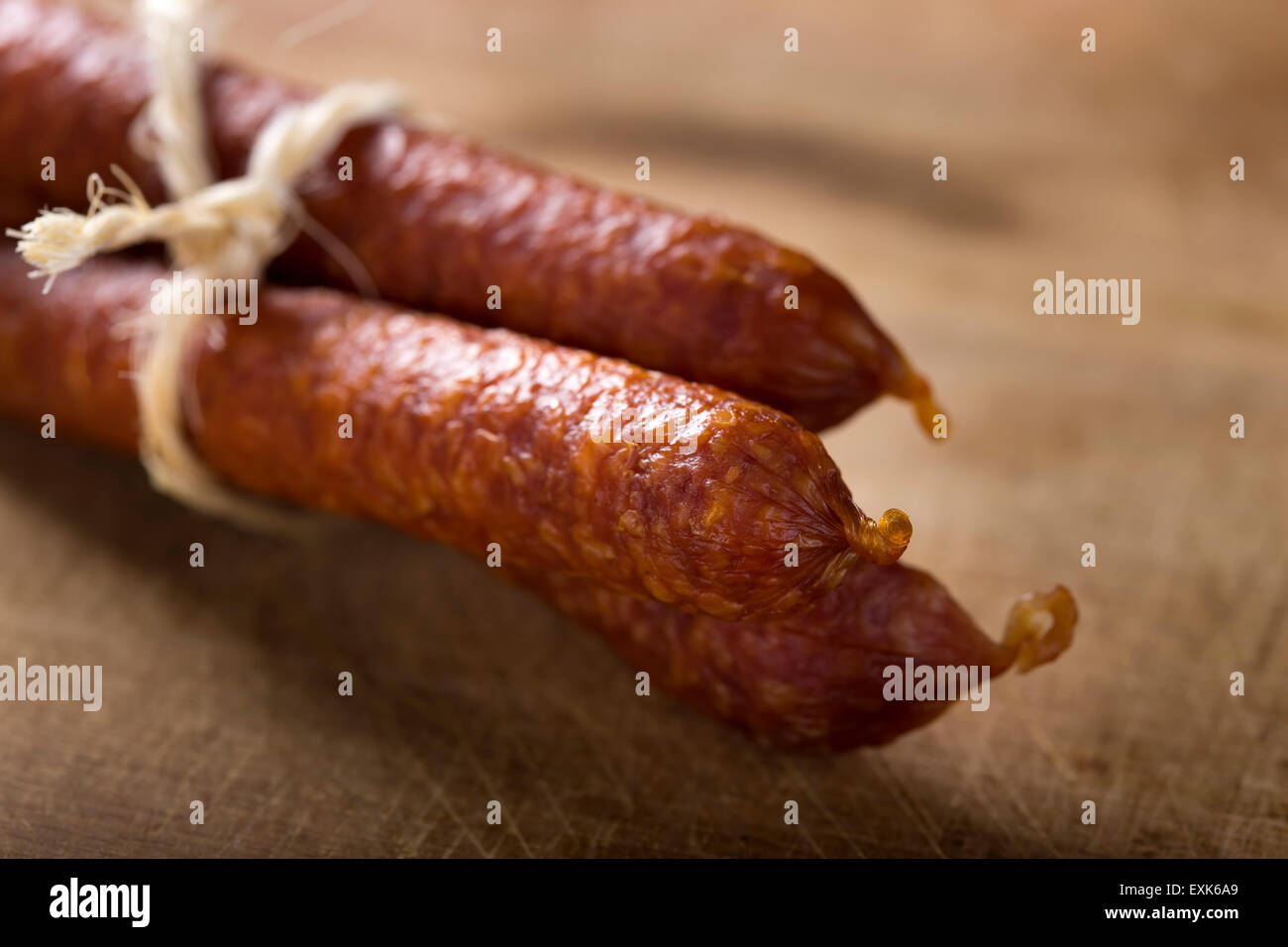 In prossimità di alcuni sottili di salsiccia affumicata su uno sfondo di legno Foto Stock