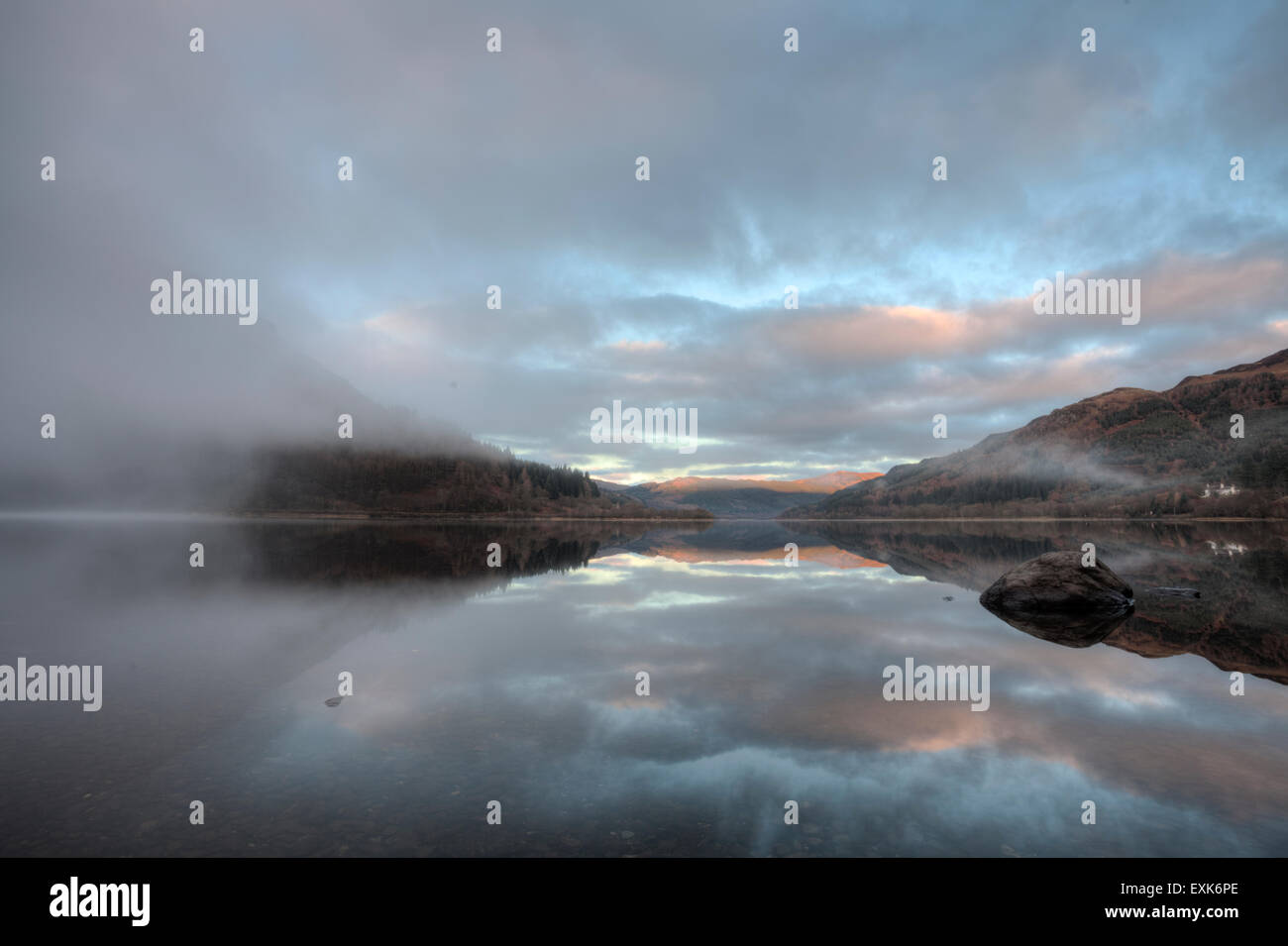 Loch Lubnaig su un bellissimo novembre di mattina con la nebbia il sollevamento che mostra un riflesso perfetto Foto Stock