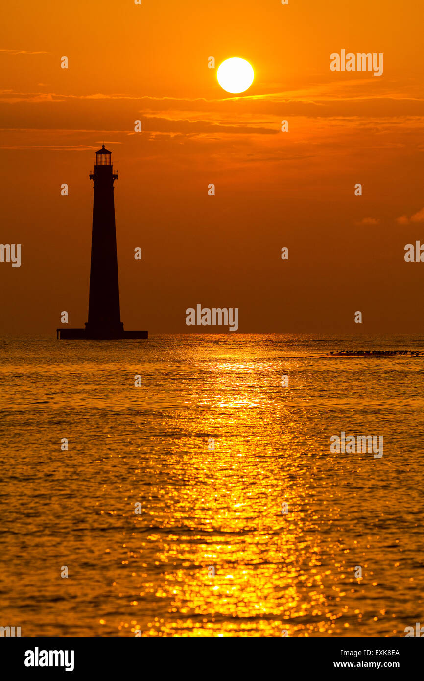 Sunrise over Morris Island Casa di luce visto dalla follia spiaggia Luglio 13, 2015 in follia Beach, SC. Morris faro risale al 1767 e la terra intorno ad esso lentamente erosi fino a ora siede completamente circondata da acqua. Foto Stock