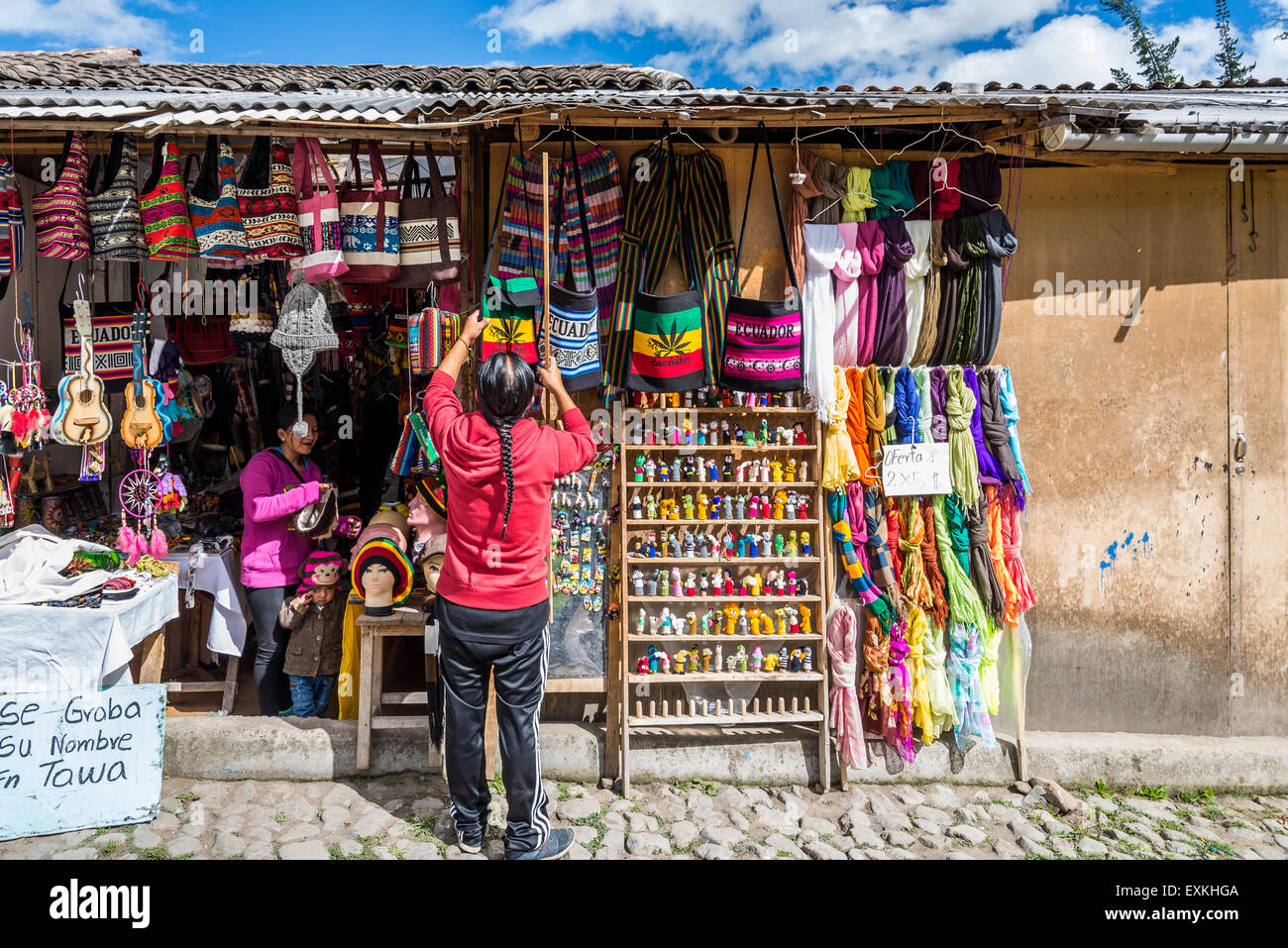 Negoziante la visualizzazione di mercanzie presso un negozio di souvenirs. Otavalo, Ecuador. Foto Stock