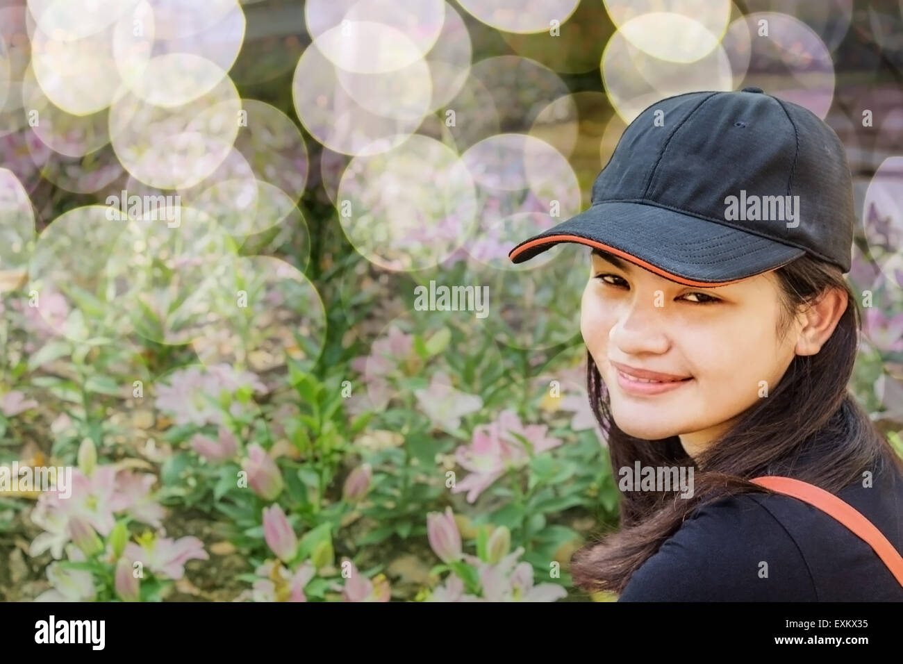 Felice Asian Thai giovane donna si rilassa in Flower Garden Foto Stock