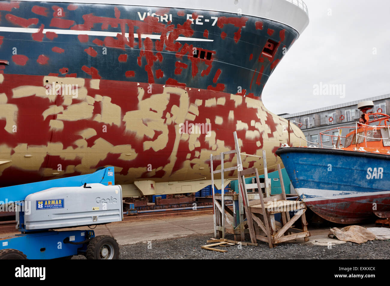La riparazione e la verniciatura scafo di una nave in bacino di carenaggio nel porto di Reykjavik Islanda Foto Stock