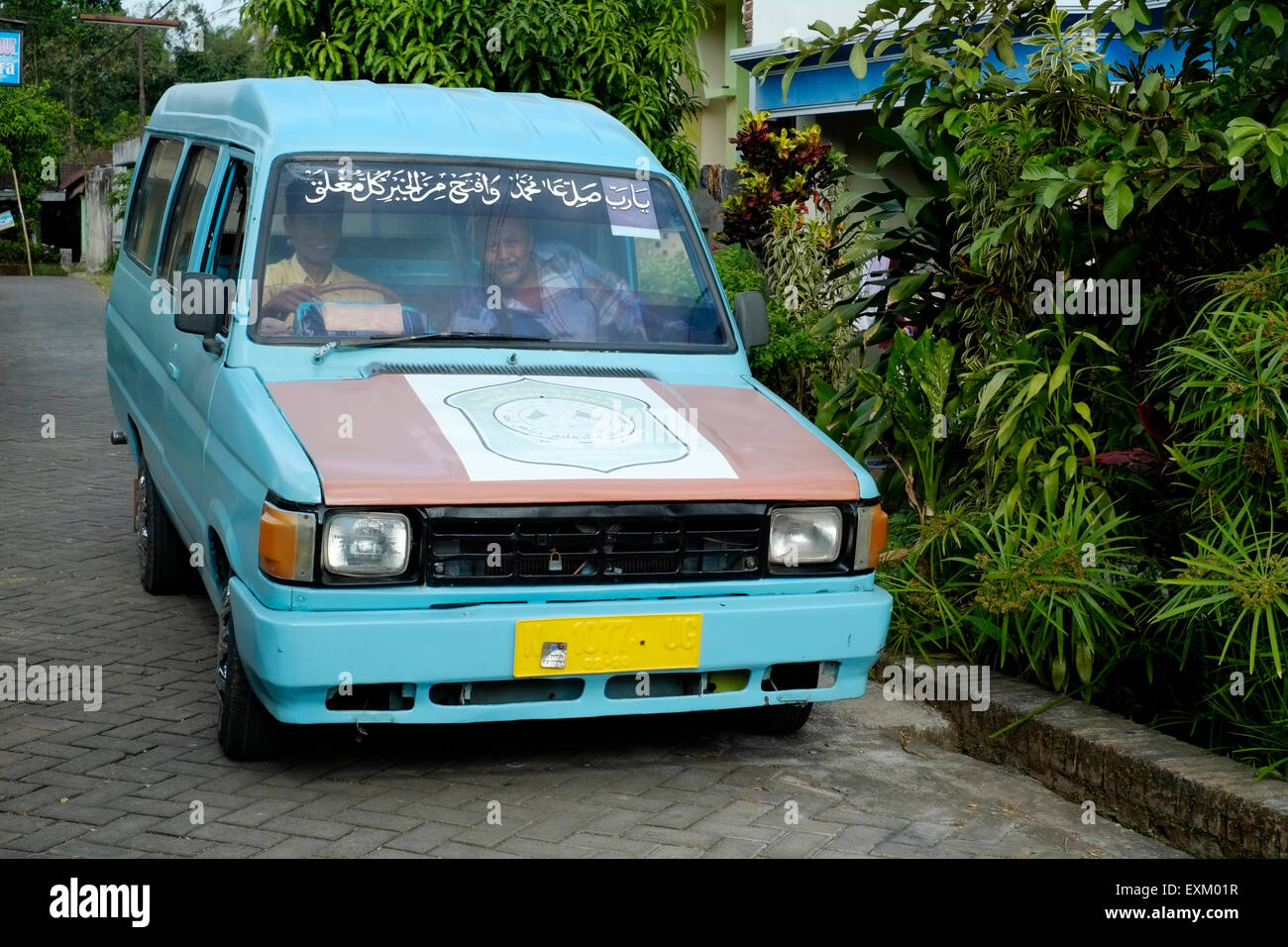 Il conducente in un angkot attende per consentire ai passeggeri di salire a bordo a malang java indonesia Foto Stock